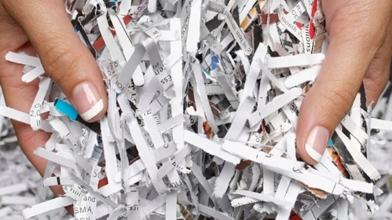Woman holding heap of shredded paper, close-up of hands